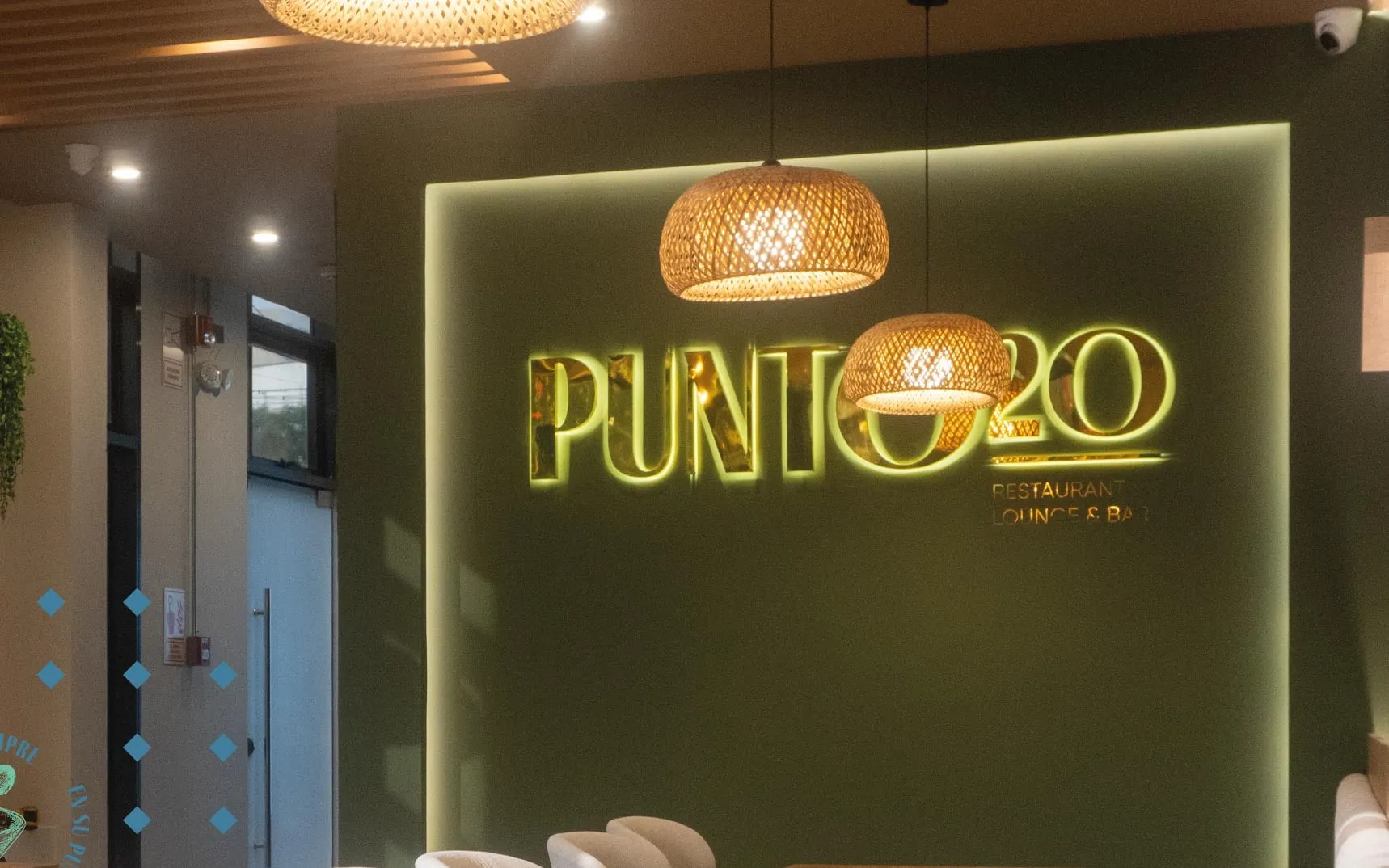 Muro Punto20 con logo iluminado y trama de rombos de marca